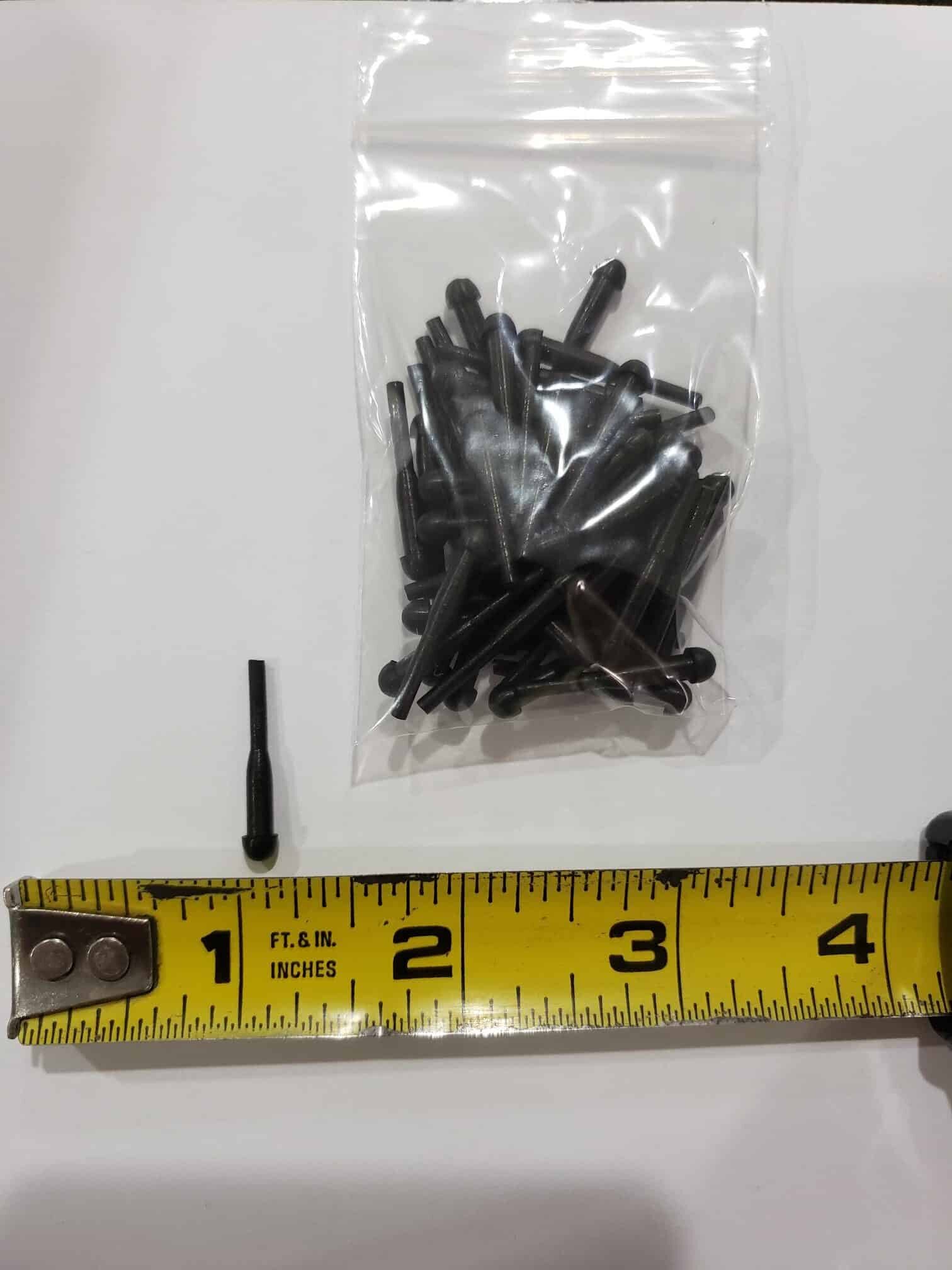 A small black plastic pin from Bulk Rubber Bumpers is shown next to a measuring tape at about 1.5 inches, with a bag of matching pins in the background.
